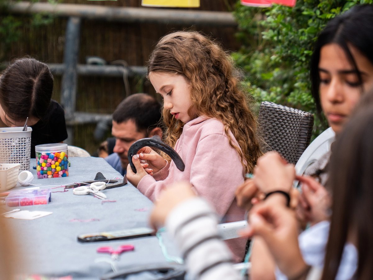 A child crafting a dream catcher with a real horseshoe at the Yes Day art station
